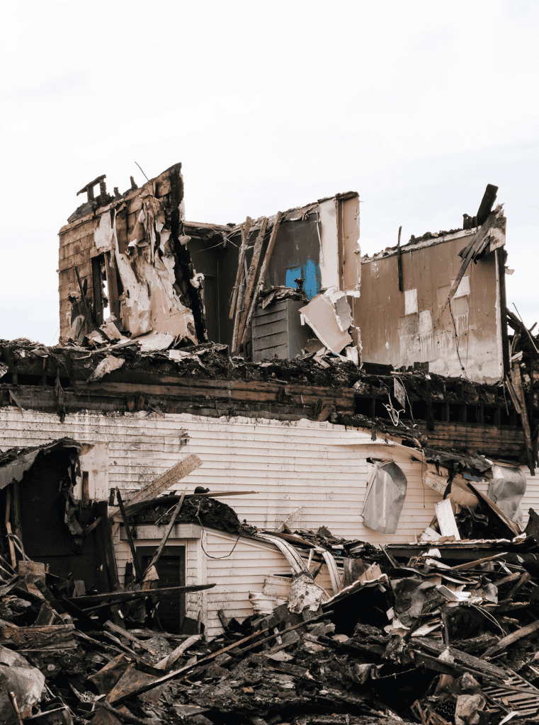 Devastated house with significant structural damage and debris.